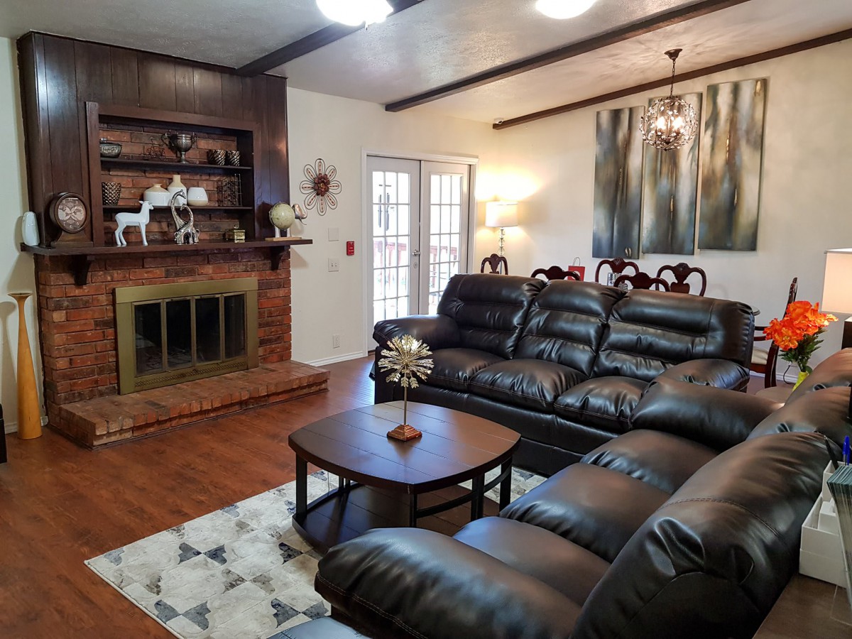 Cozy living room featuring a leather sofa, fireplace, and elegant decor.