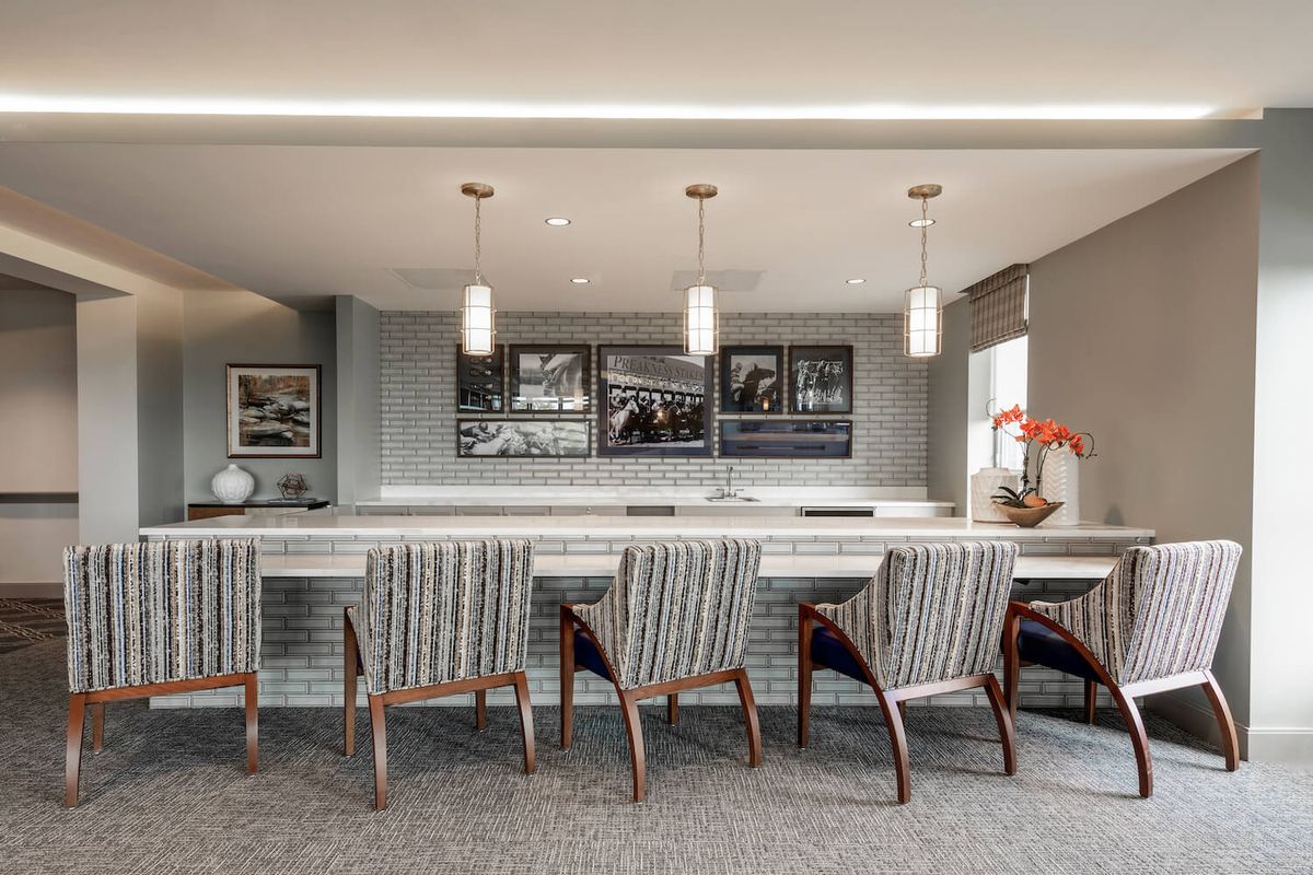 A modern bar area featuring sleek counter seating and stylish pendant lighting.