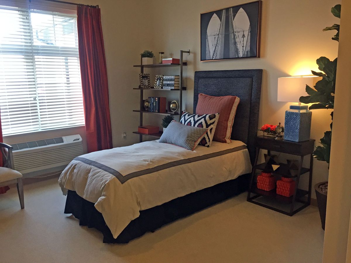 A neatly arranged bedroom with a single bed, shelving, and stylish decor.