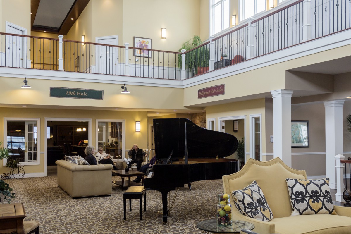 A spacious lobby with a grand piano and comfortable seating areas.