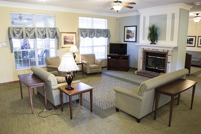 A cozy living room with sofas, a fireplace, and a television.