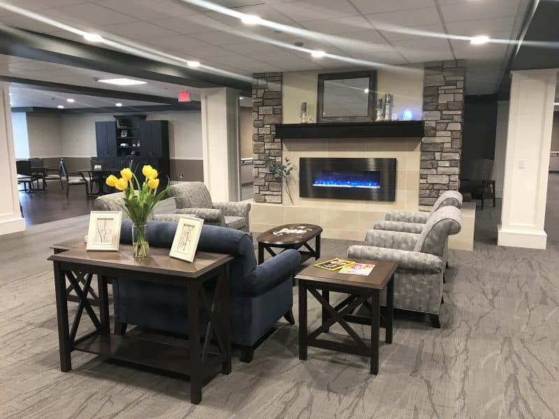 A modern living room with a sofa, chairs, and a fireplace.