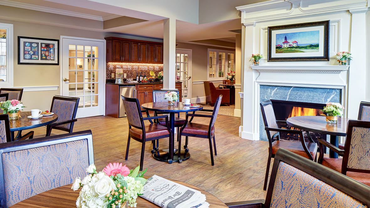 A cozy and elegantly decorated living and dining area with a fireplace.