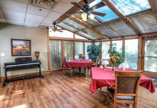 A cozy dining area featuring red table settings and ample natural light, perfect for enjoying a meal.