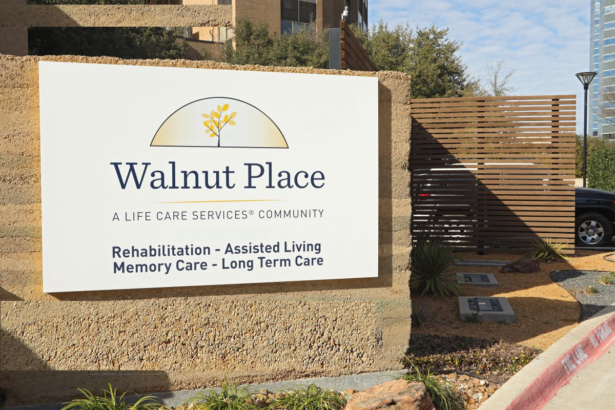 Sign for Walnut Place, a life care services community offering rehabilitation, assisted living, memory care, and long-term care.