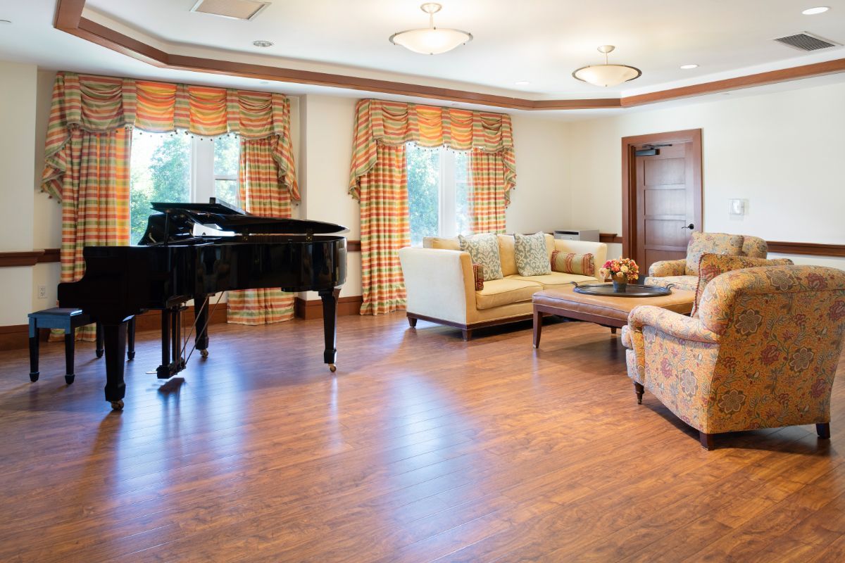 A spacious living room featuring a grand piano and elegant furniture.