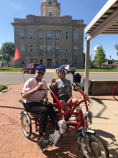 Enjoying a sunny day with ice cream on a tandem bicycle.
