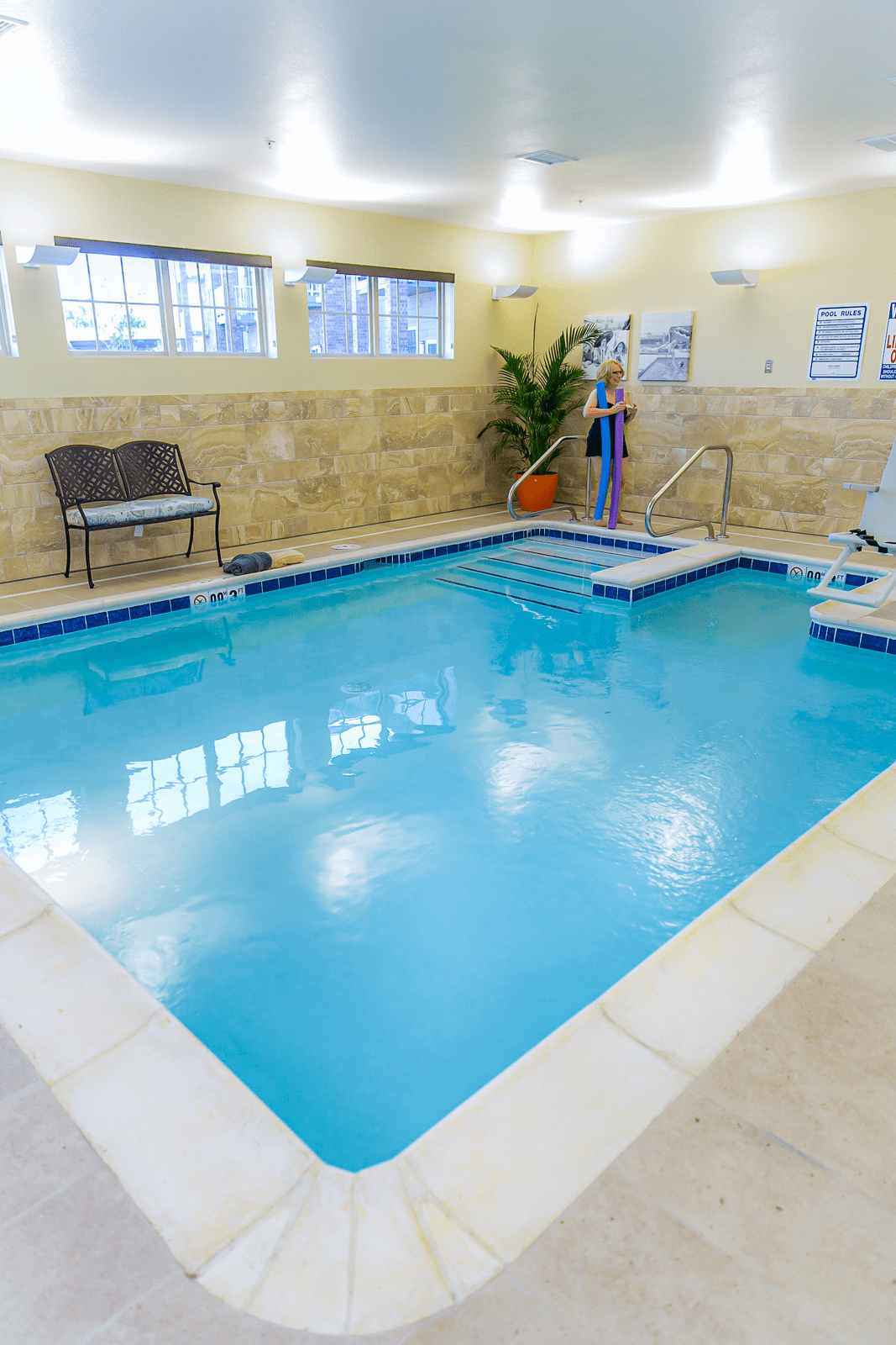 A cozy indoor swimming pool with seating and decor.