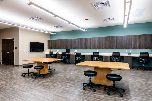 A modern classroom setup featuring several workstations and collaborative tables.