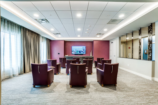 A modern conference room setup with seating and a television for presentations.