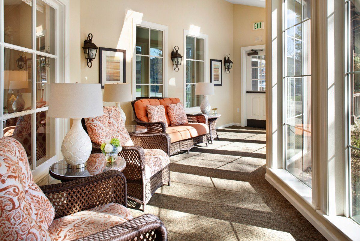 A cozy sunroom with wicker furniture and large windows letting in natural light.