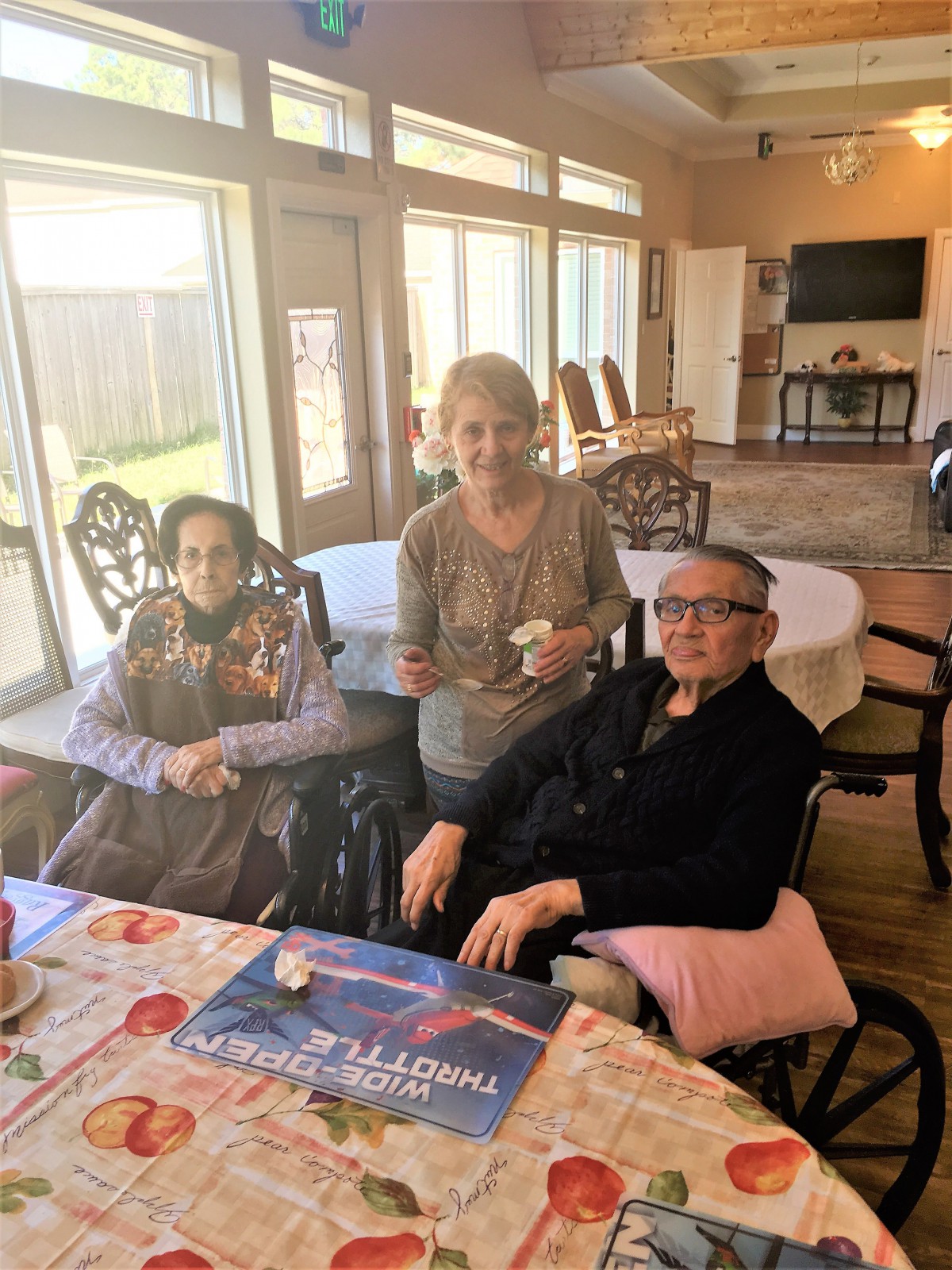 A group of seniors sitting together indoors at a table in a well-lit room.