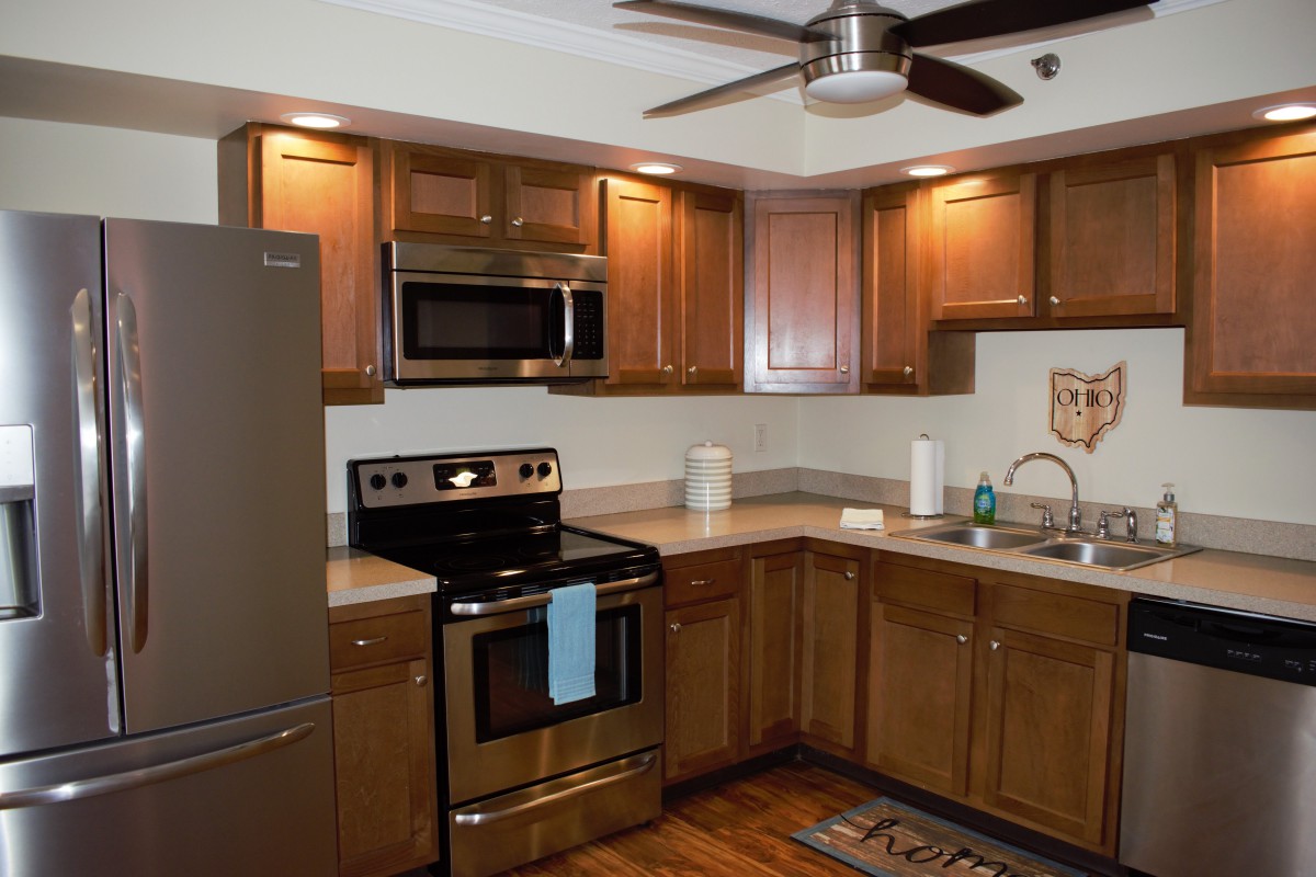 A modern kitchen with wooden cabinets and stainless steel appliances.