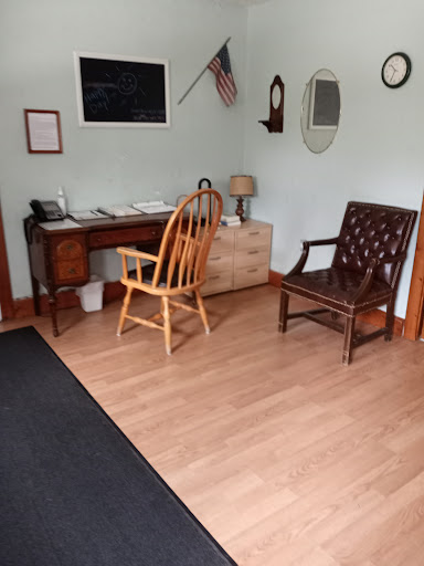 A cozy and inviting interior featuring a wooden desk, two chairs, and a light-colored floor.