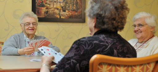 Two elderly individuals enjoying a game of cards, fostering connection and leisure.