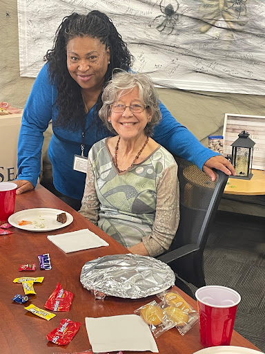 A joyful moment captured during a community gathering, featuring two smiling individuals sharing a meal.