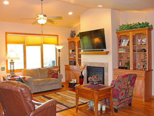 A cozy living room featuring a fireplace, comfortable seating, and ample natural light.