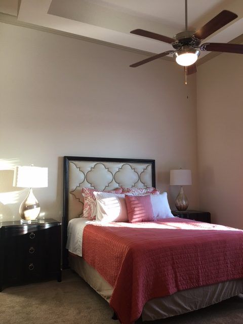 A cozy bedroom with a well-made bed, matching bedside tables, and ambient lighting.