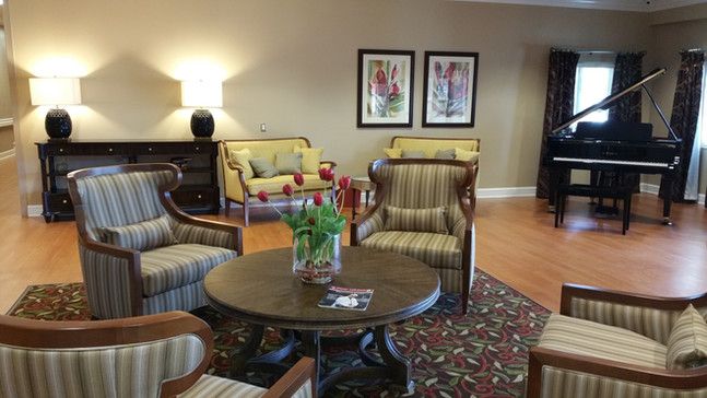 A cozy living room setup with armchairs, a sofa, and a coffee table adorned with flowers.