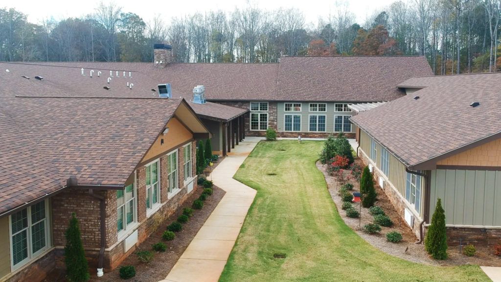 A view of a modern building complex with manicured lawns and a central walkway.