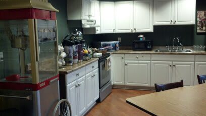 A kitchen with white cabinets and various appliances on the countertop.