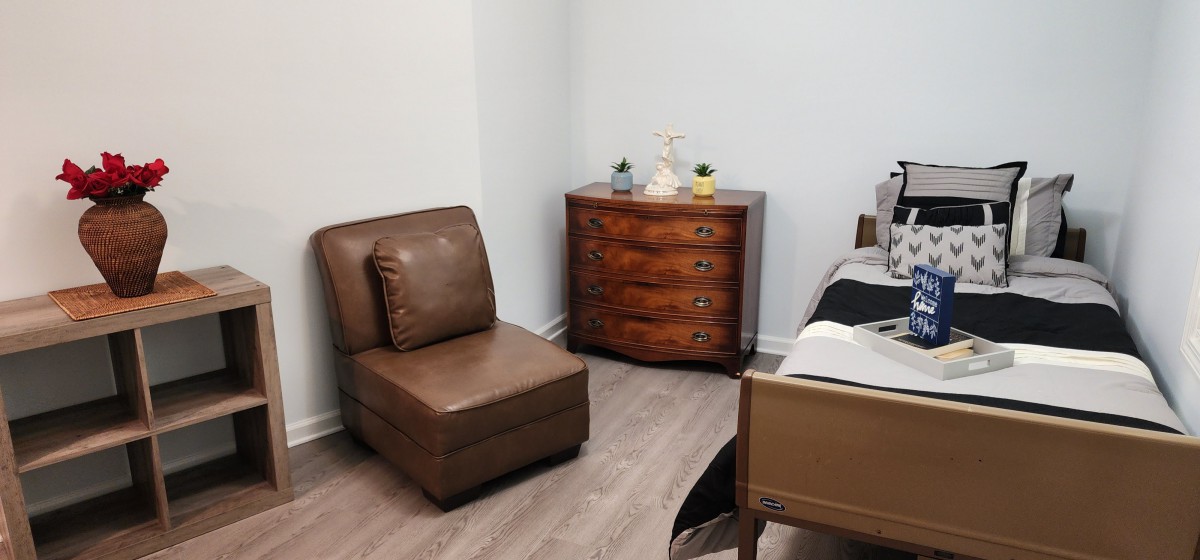 A cozy bedroom corner featuring a leather chair and a wooden dresser.
