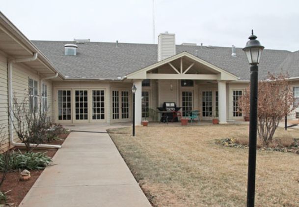 A single-story building with a covered patio and a walkway leading up to it.