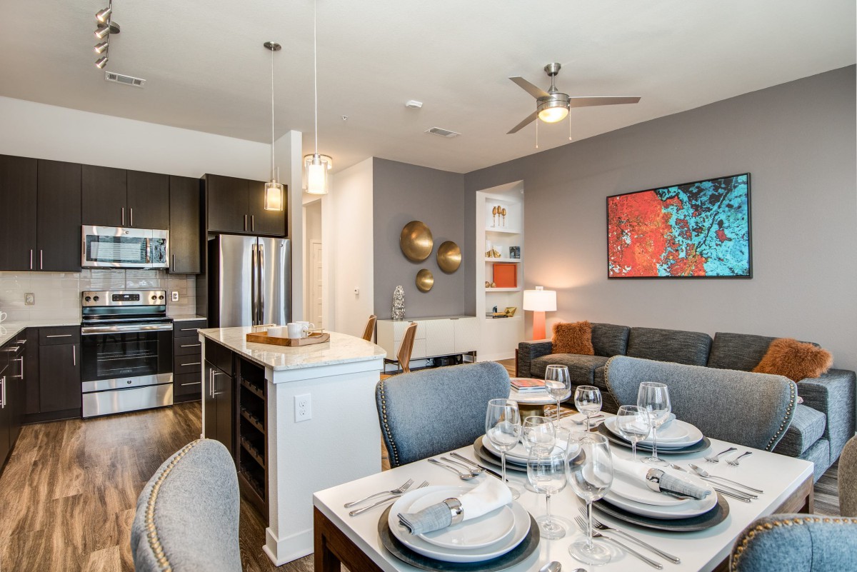 A modern open-plan apartment featuring a well-designed kitchen and dining area.