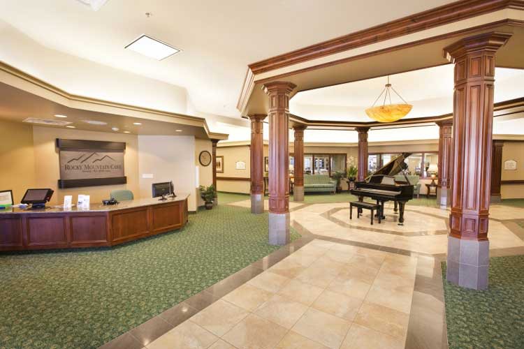 An elegant hotel lobby with a reception desk and grand piano.