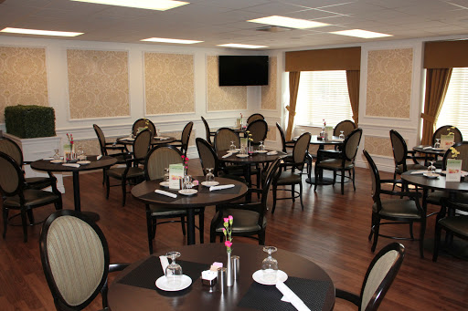 A spacious and elegantly designed dining area with well-set tables and comfortable seating.