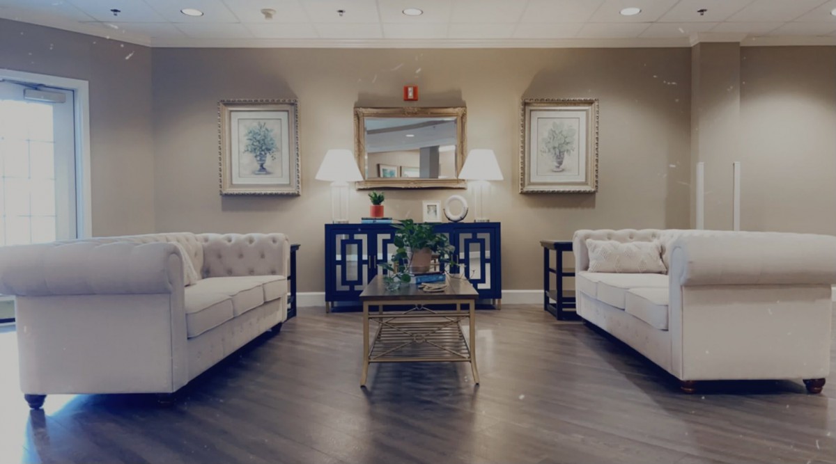 A well-decorated living room featuring two sofas, a central coffee table, and elegant lighting and artwork.