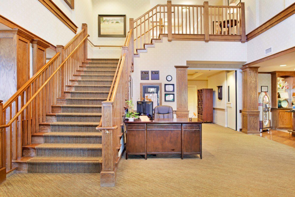 A welcoming reception area with a wooden staircase and desk.