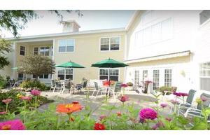 A charming outdoor patio area with colorful flowers and umbrella-shaded seating.