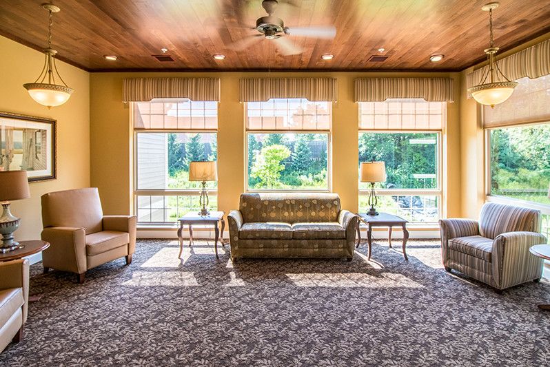 Spacious living room with large windows and classic furniture.