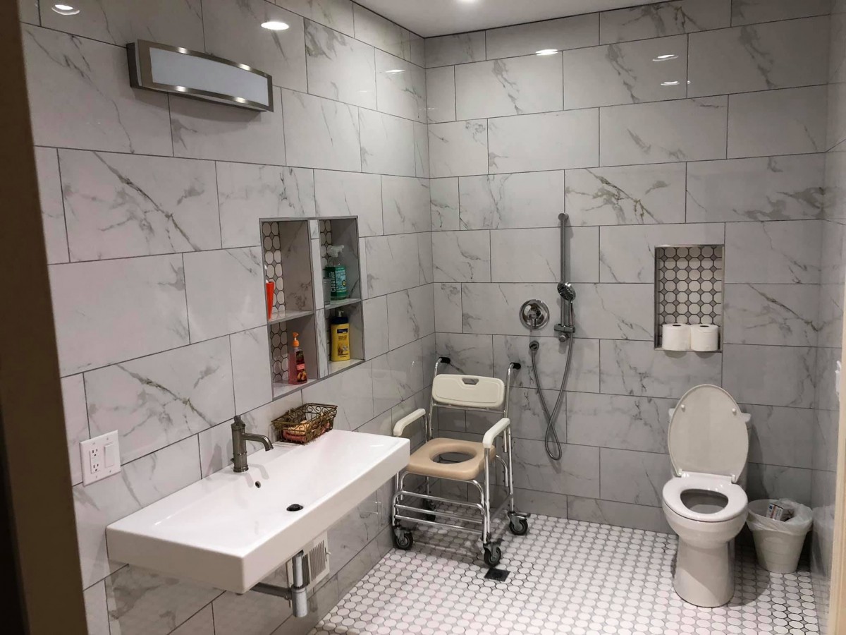 A modern, accessible bathroom equipped with a wheelchair-friendly shower area and toilet.
