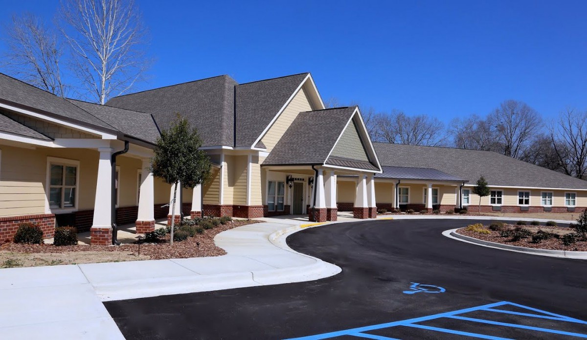 A suburban building with a parking area and clear blue skies.