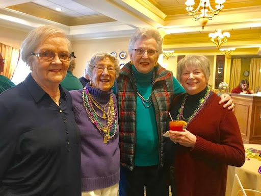 A joyful gathering of friends celebrating together with smiles and colorful accessories.