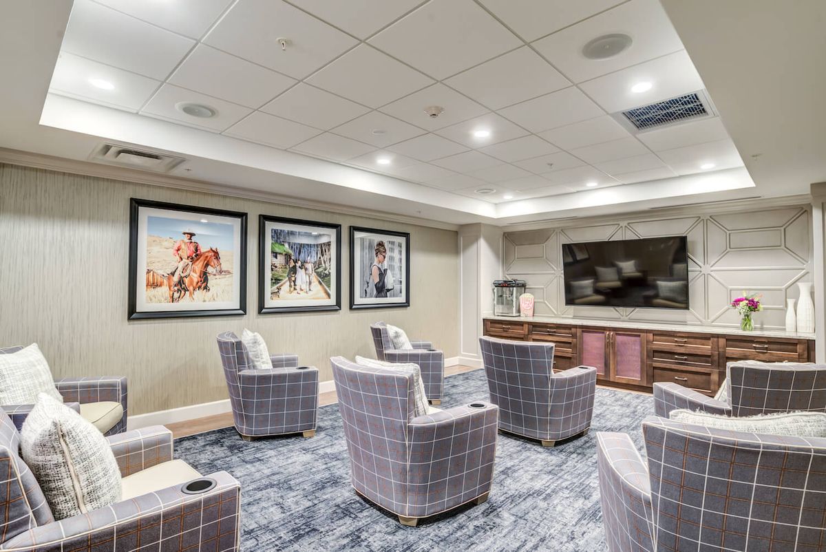 A modern home theater room with comfortable seating and decorative artwork on the walls.