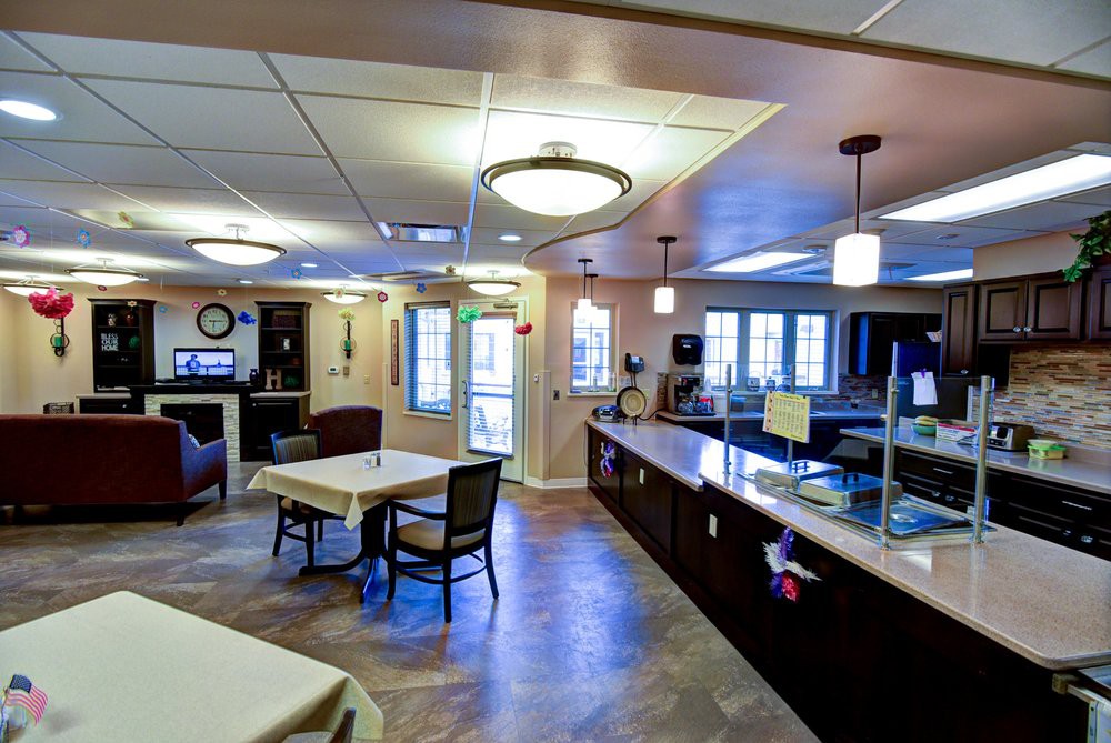 A modern dining area and kitchen with comfortable seating and bright lighting.