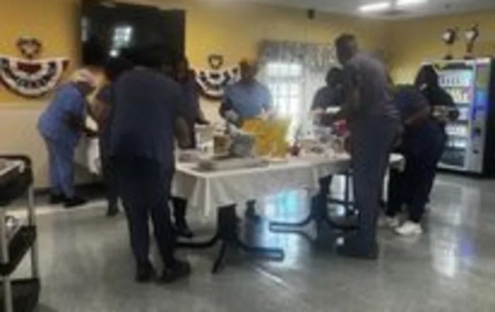A group of people gathered around a table with food.