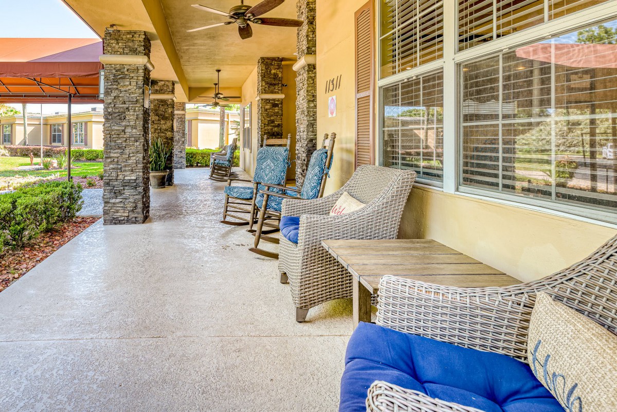 A cozy porch with comfortable seating and ceiling fans.