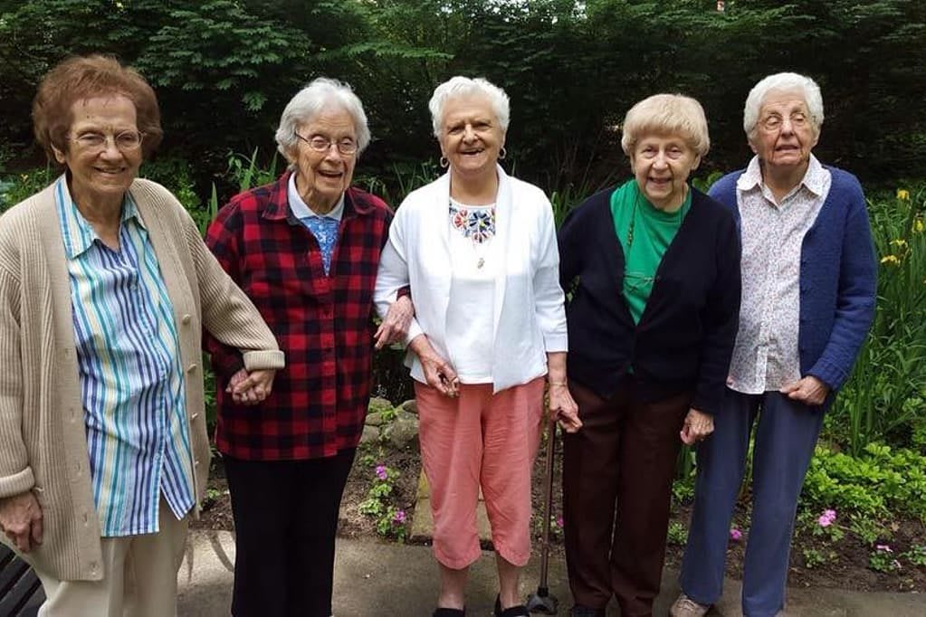 A group of elderly women enjoying time together outdoors.