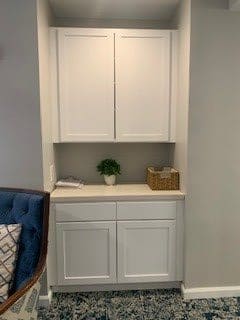 A minimalist white cabinet with decorative elements in a modern interior setting.