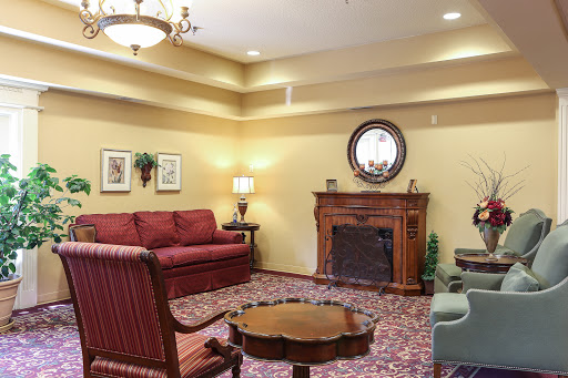 A cozy living room featuring a red sofa, classic fireplace, and decorative elements.