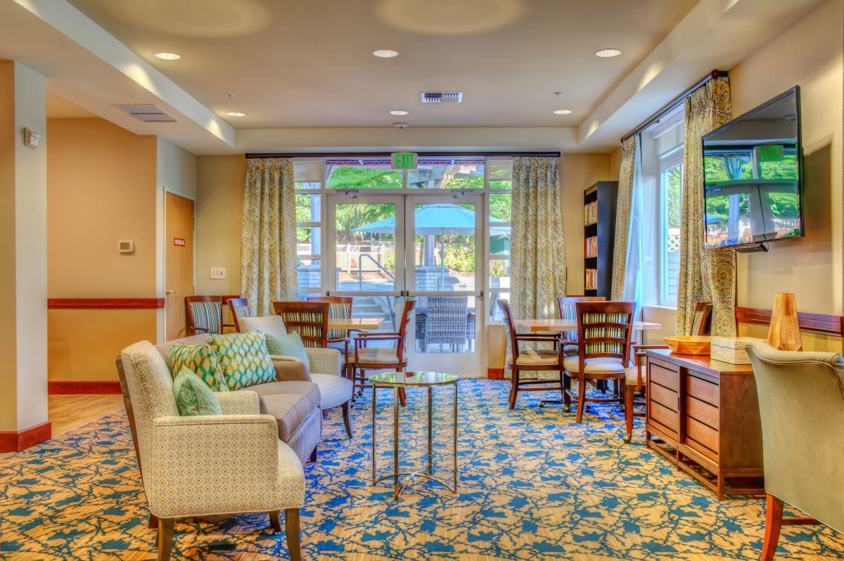 A cozy and well-decorated living room with sofas, chairs, and a patterned carpet.