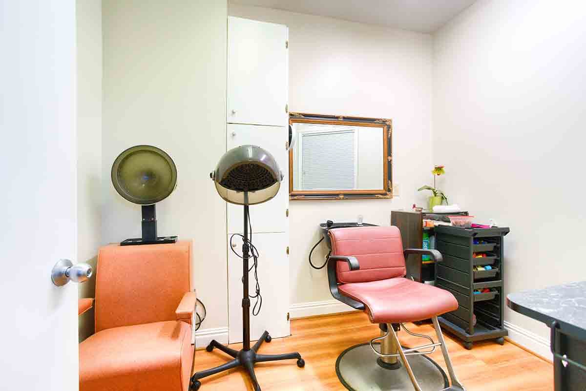 A cozy salon setup featuring chairs and hair dryers with a mirror on the wall.