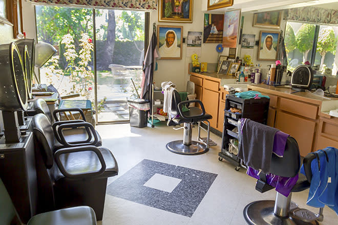 A bright and welcoming barbershop interior with chairs, mirrors, and various hair styling equipment.