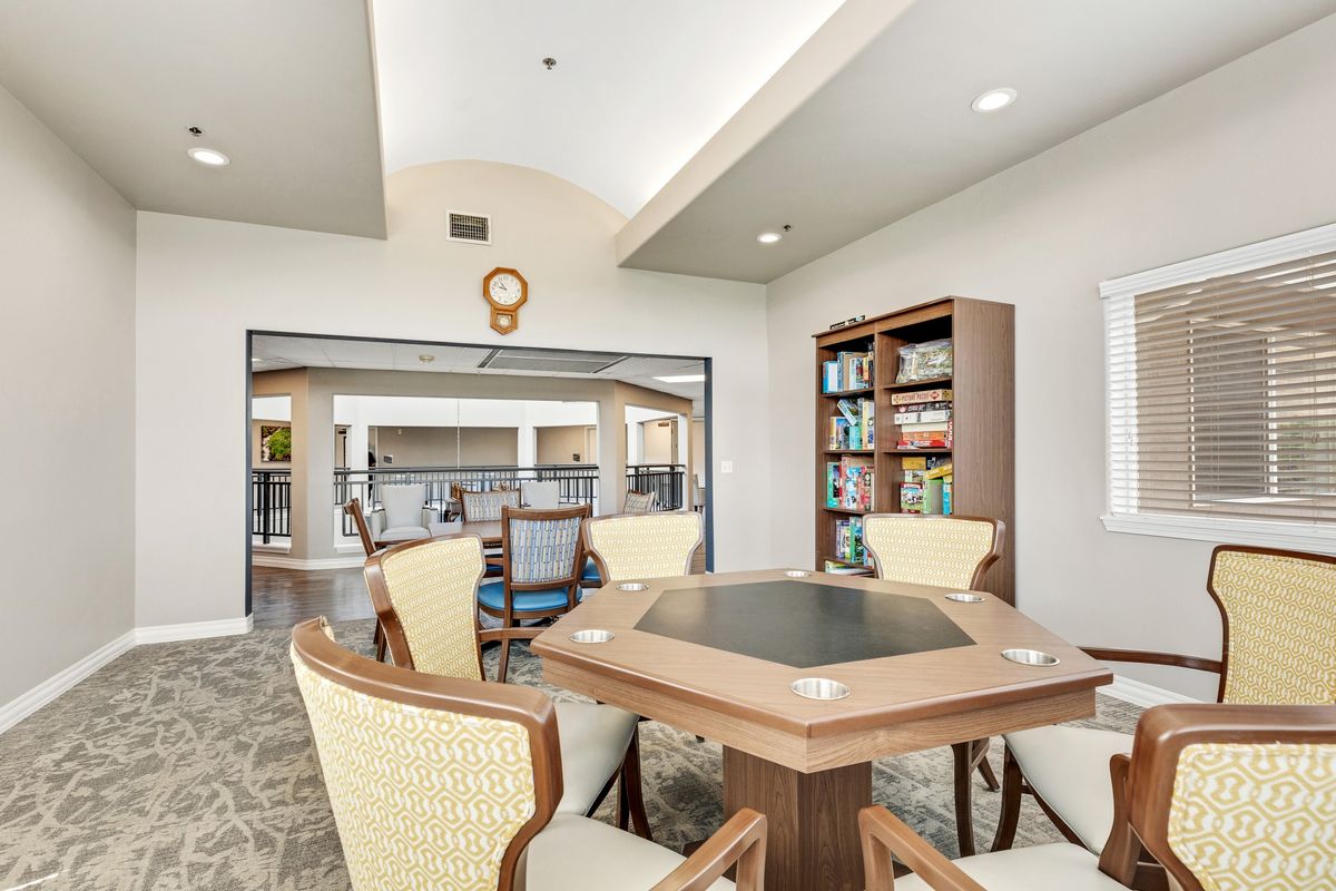 A well-lit room with a table and chairs, surrounded by bookshelves, suitable for studying or meetings.