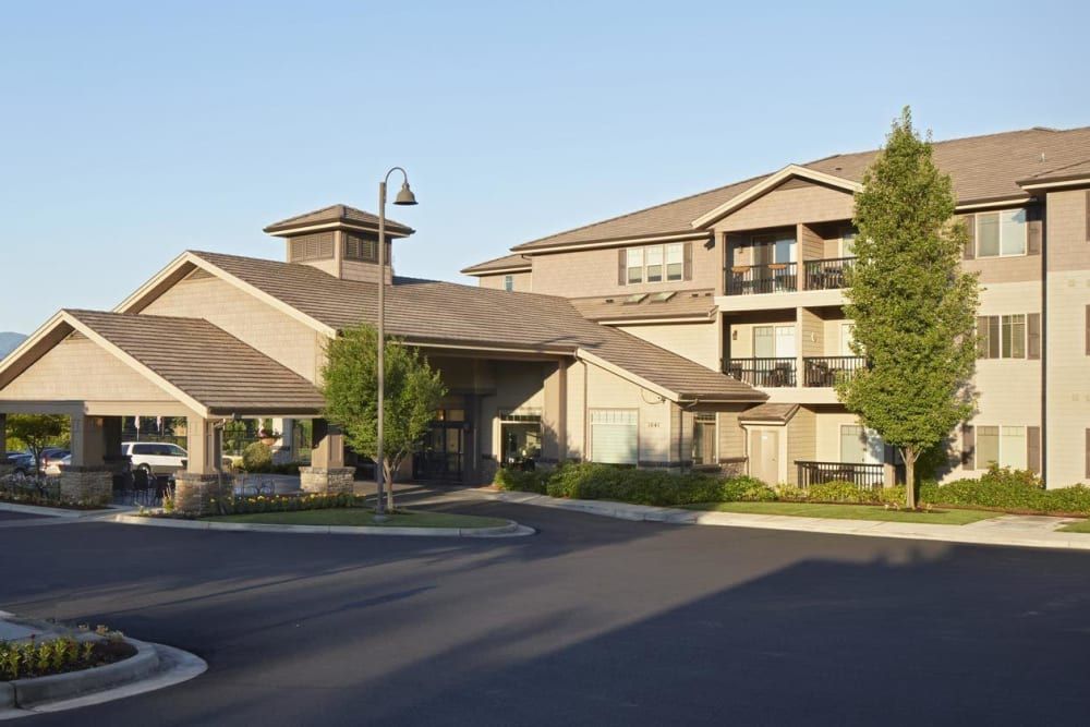 A modern apartment complex with well-maintained landscaping during the daytime.