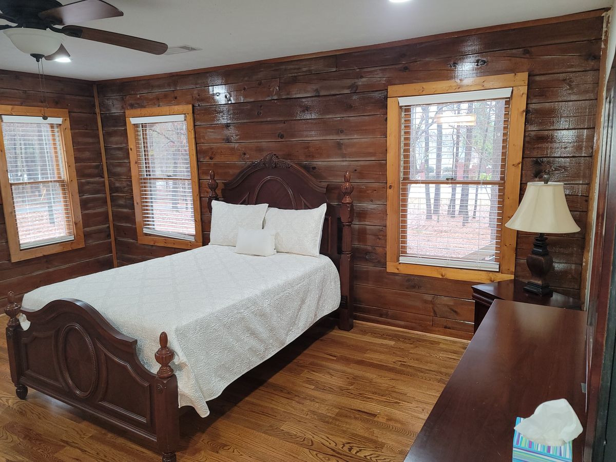 A cozy bedroom in a log cabin with wooden walls and a double bed.
